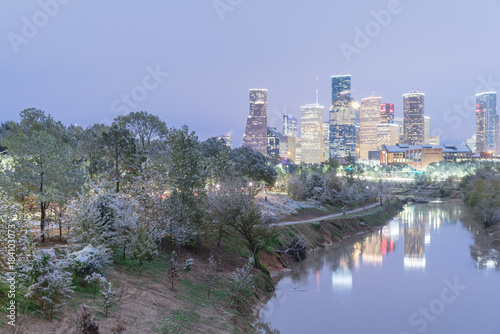 Unusual snowfall along Bayou River bank with downtown Houston, Texas, USA skylines city lights reflection at sunrise/twilight. Snow is extremely rarely in Houston and happen only 35 times since 1895 photo