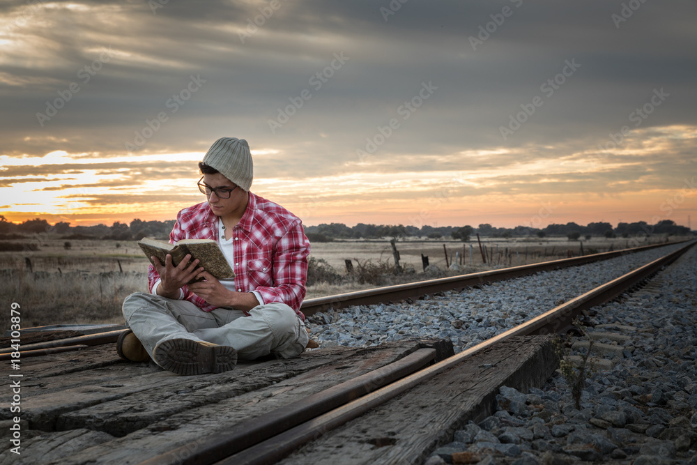 Fototapeta premium Young boy with red shirt and yellow boots in sunset
