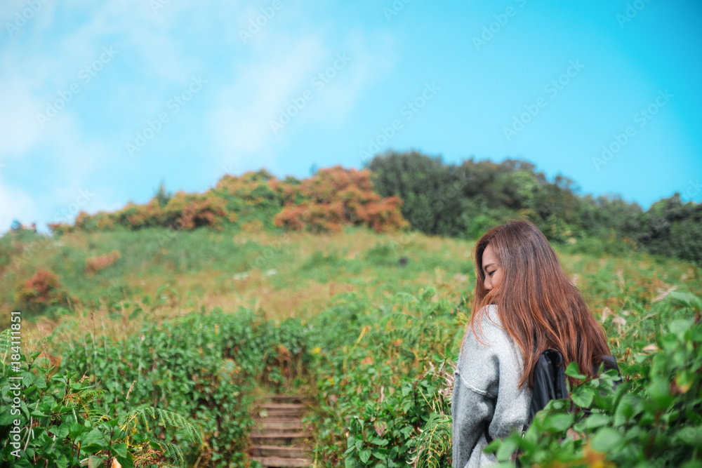 A beautiful Asian woman tourist walking and trekking along the mountains in tropical forest with feeling happy A beautiful Asian woman tourist walking and trekking along the mountains in tropical forest with feeling happy