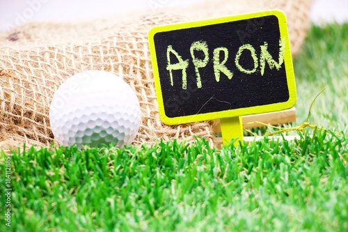 Apron sign with golf ball on green grass