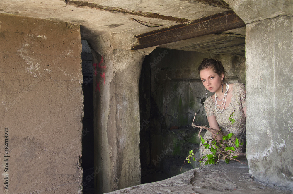 woman with spiky bouquet in hand in the ruins of the old concrete buildings