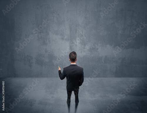 Businessman standing in front of urban wall
