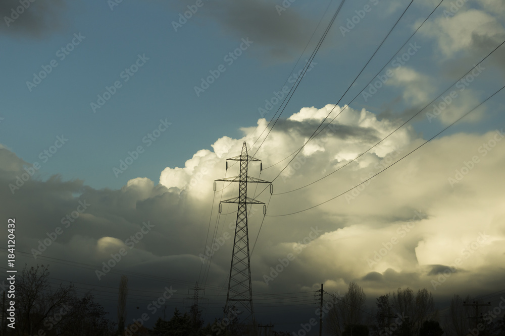 electricity pylon clouds trees enviroment
