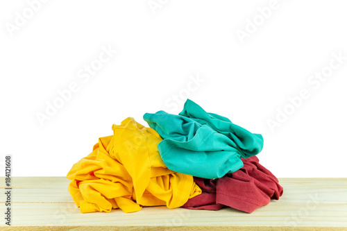 Pile of clothes t-shirt colorful clothing on wood,white background.
