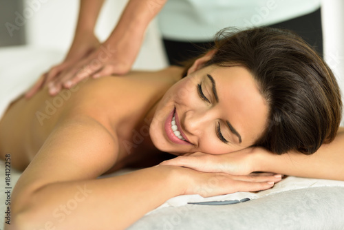 Young female receiving a relaxing back massage in a spa center.