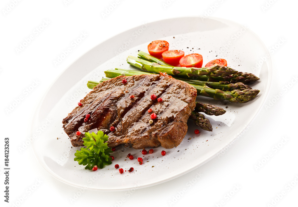 Grilled steak with asparagus on white background Grilled steak with asparagus on white background