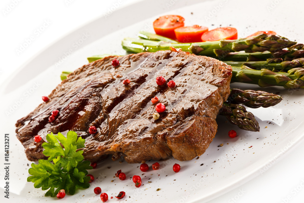 Grilled steak with asparagus on white background