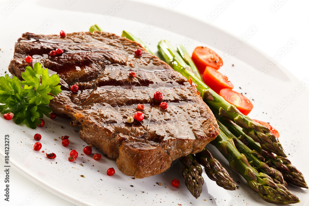 Grilled steak with asparagus on white background Grilled steak with asparagus on white background