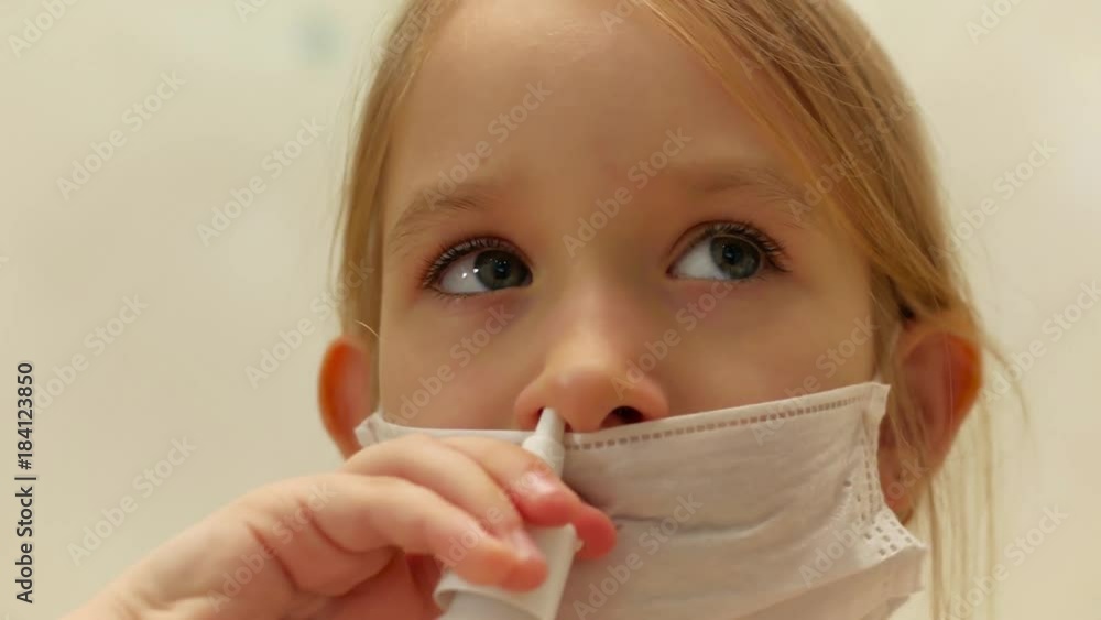 Mother spraying a nose of a little girl, home treatment. Mother spraying a nose of a little girl, home treatment.