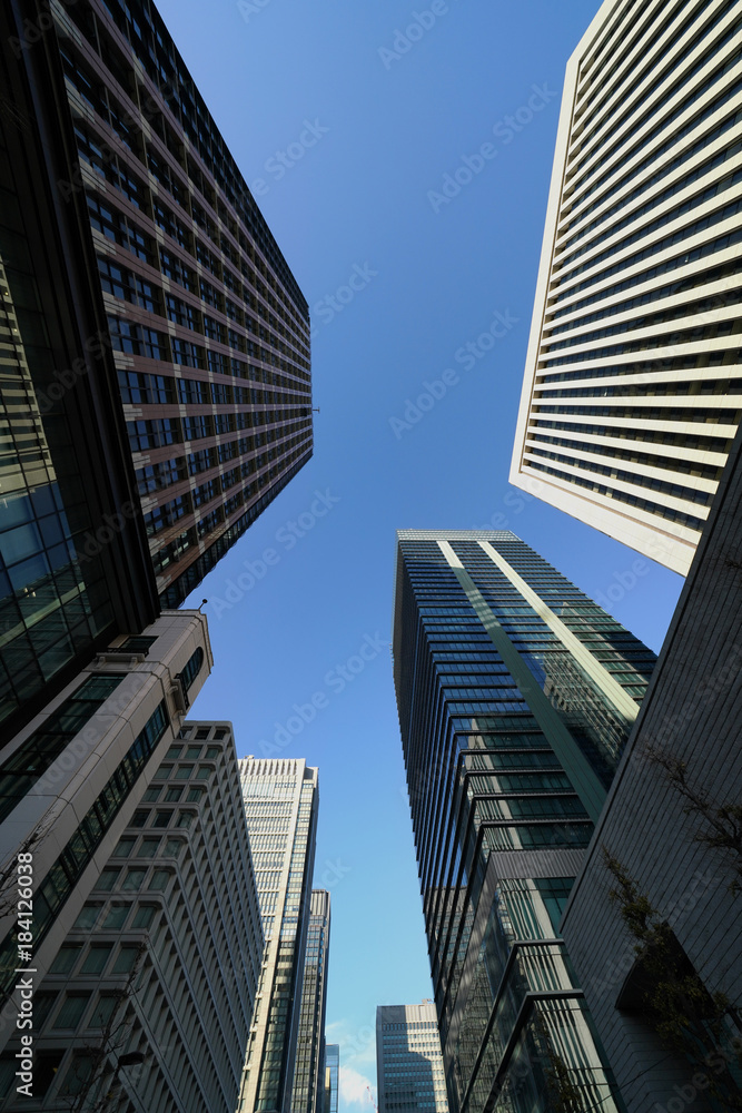 日本の東京都市風景「丸の内のビジネス街から青空を望む」縦写真