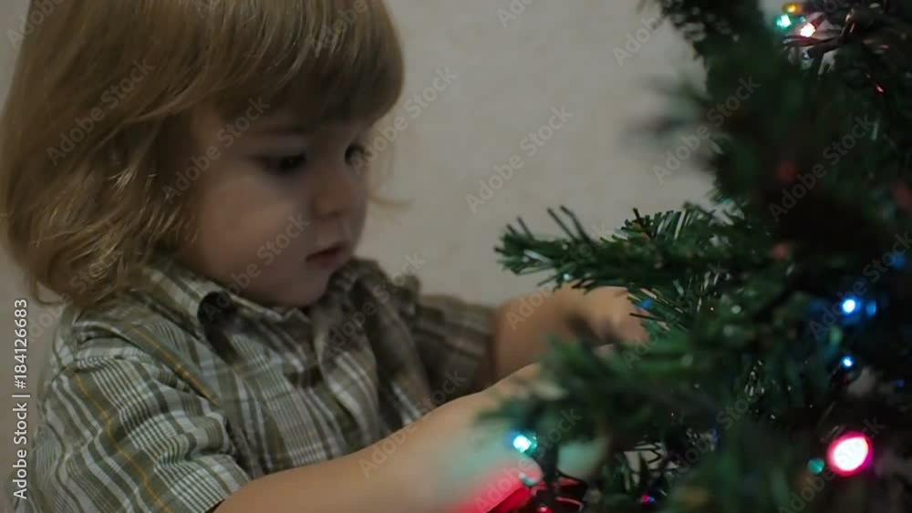 Cute little boy decorates the Christmas tree. Cute little boy decorates the Christmas tree.