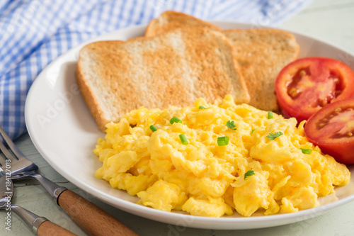 Scrambled egg served with toast and tomato