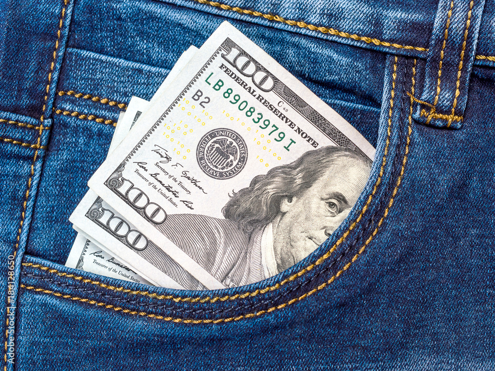 One hundred dollar bills in front pocket of jeans. One hundred dollar bills in front pocket of jeans.