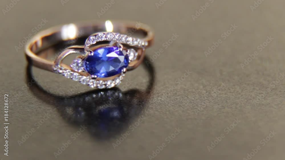 Beautiful engagement female gold ring with precious stones on a black background Beautiful engagement female gold ring with precious stones on a black background