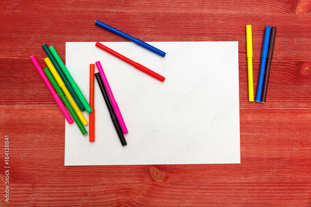 Naklejka premium colored felt-tip pens on a wooden table