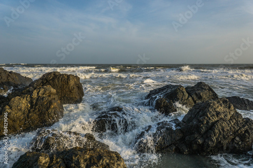 Waves crashing over black rocks on the sea shore. Vung Tau, Vietnam.