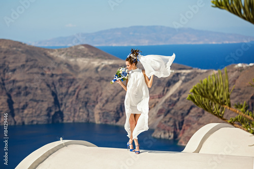 Beautiful woman in white dress with wedding bouquet © Santorines
