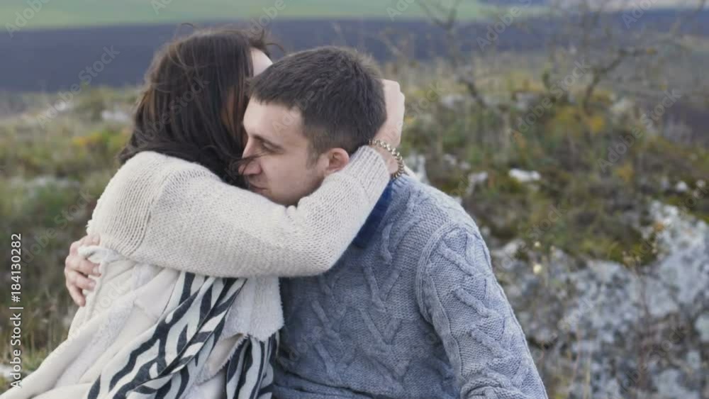Pretty girl kisses her handsome man on the rock. Slowly Pretty girl kisses her handsome man on the rock. Slowly