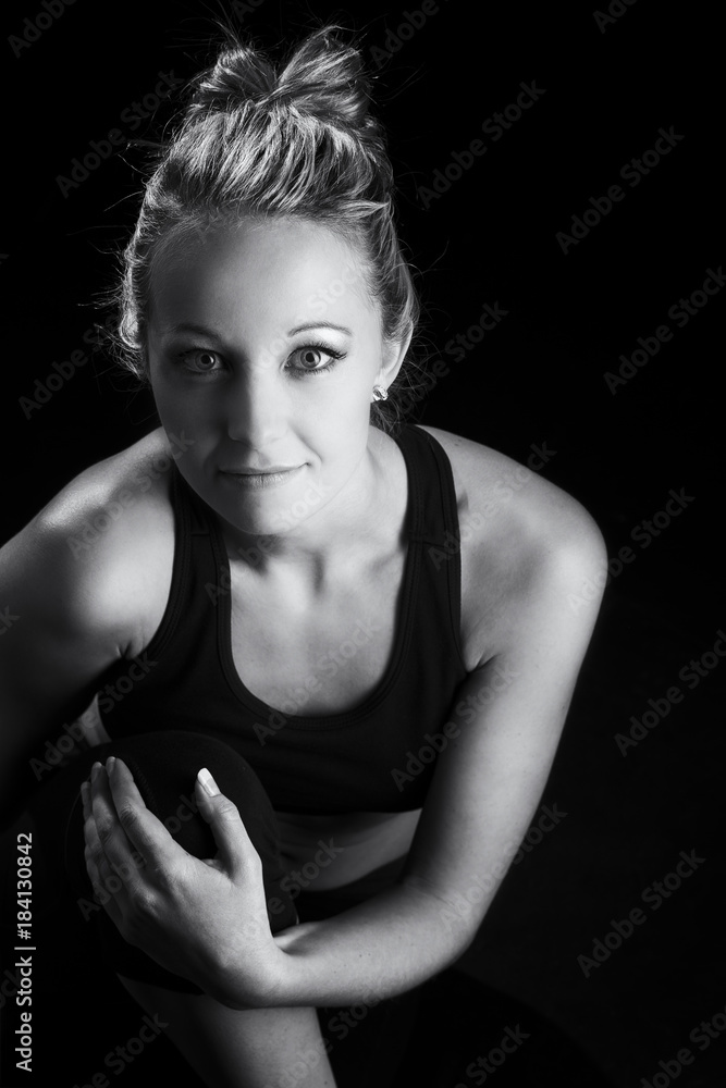 Beautiful fit and healthy blond woman portrait in black top with knee drawn up artistic conversion Beautiful fit and healthy blond woman portrait in black top with knee drawn up artistic conversion