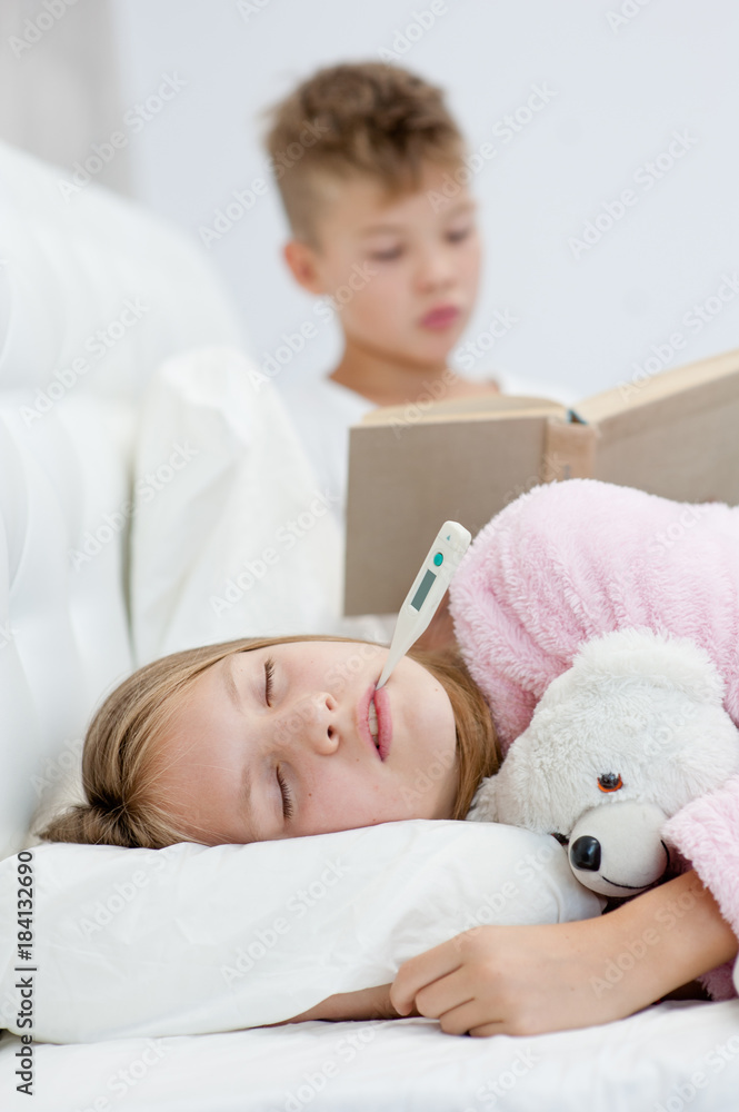 Little boy reads the book to the sick sister Little boy reads the book to the sick sister