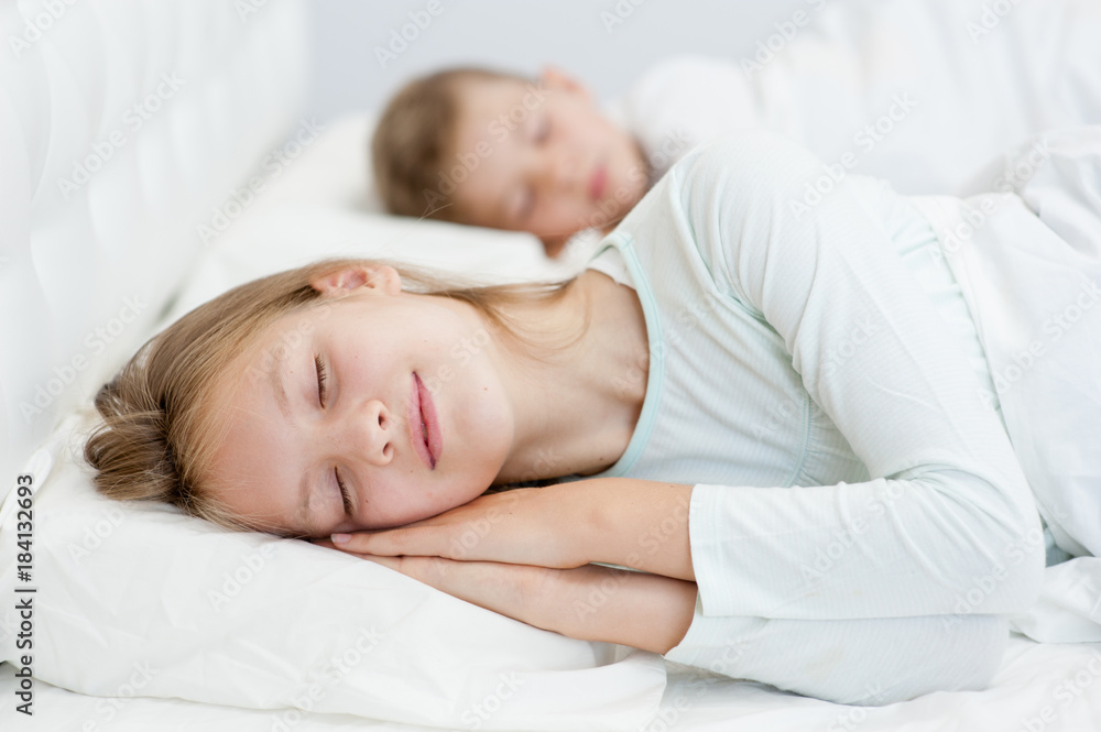 Brother and sister are sleeping on the bed together Brother and sister are sleeping on the bed together