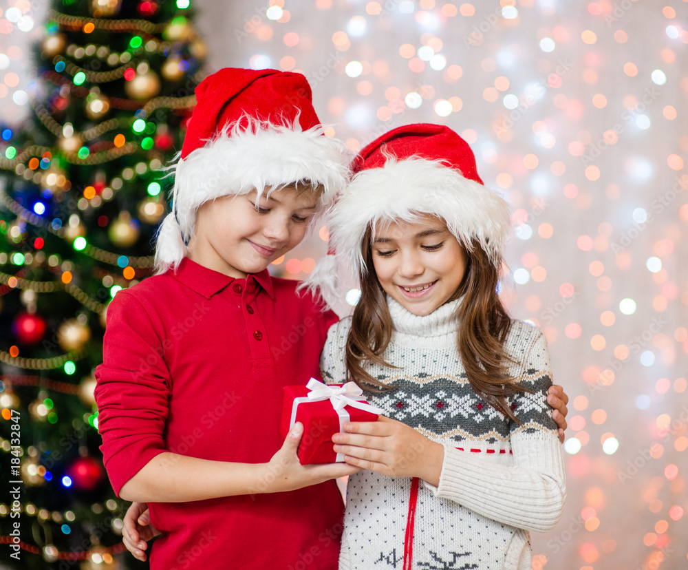 Happy boy gives the girl a gift for Christmas Happy boy gives the girl a gift for Christmas