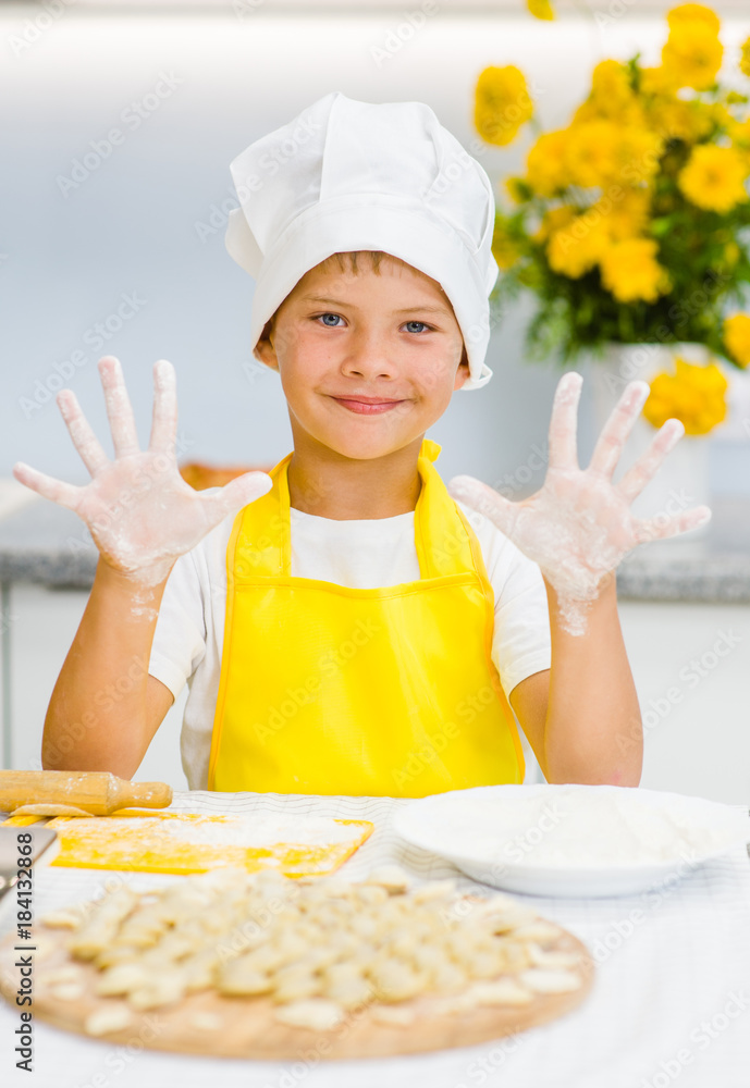 Happy boy in kitchen showing hands in flour Happy boy in kitchen showing hands in flour