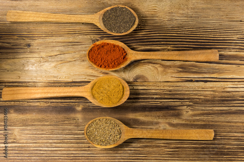 Assorted spices in wooden spoons on a table