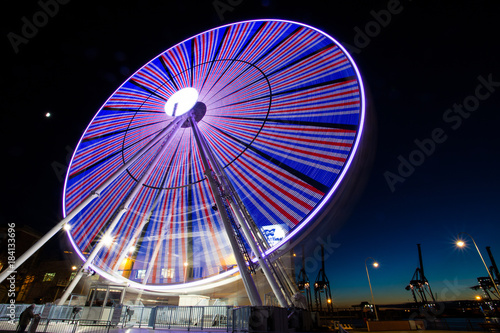 GENOA, ITALY, NOVEMBER 27, 2017 - Ferris wheel with colored lights in "Porto Antico" harbor zone in Genoa, Italy