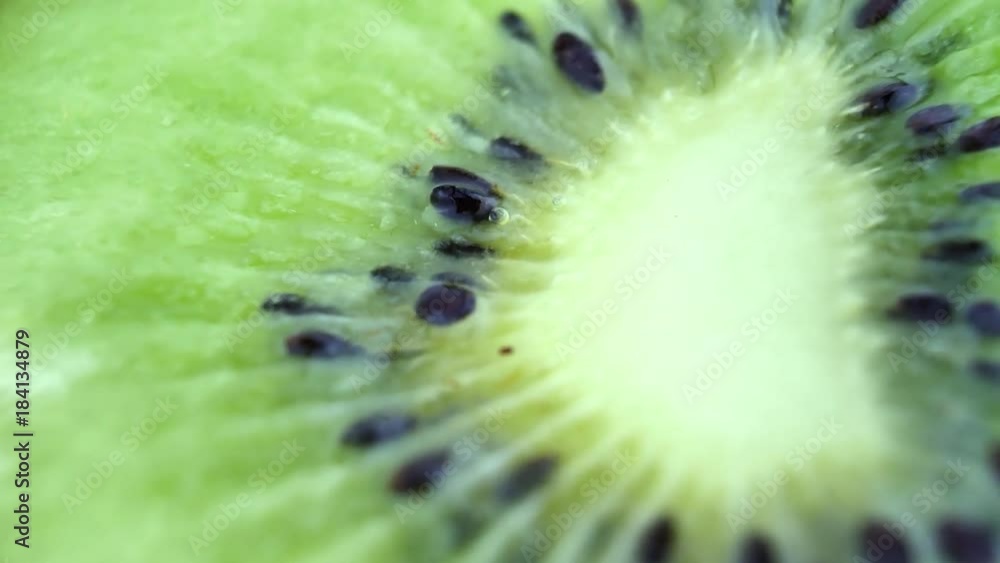 Juicy kiwi rotates as background. Macro of slice of fresh kiwi fruit isolated Juicy kiwi rotates as background. Macro of slice of fresh kiwi fruit isolated