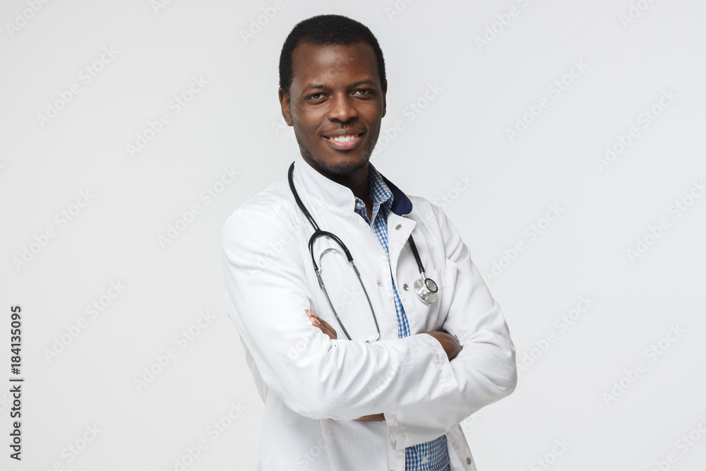 Portrait of african doctor with stethoscope around his neck, looking at the camera and smiling isolated on gray background Portrait of african doctor with stethoscope around his neck, looking at the camera and smiling isolated on gray background