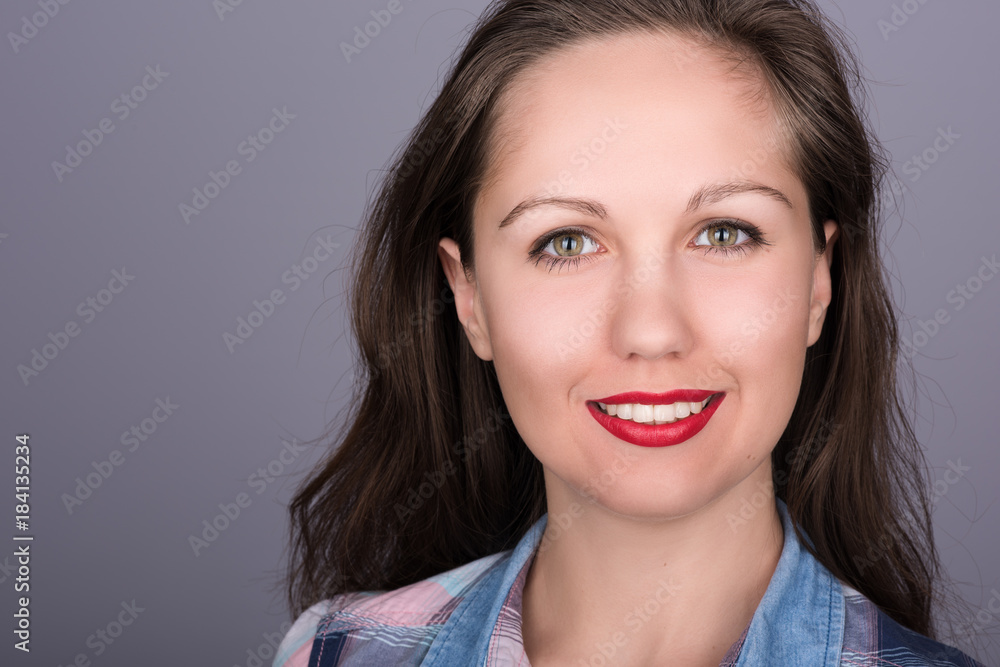 Closeup portrait of a beautiful young woman with flowing hair and red lipstick on a neutral gray background Closeup portrait of a beautiful young woman with flowing hair and red lipstick on a neutral gray background