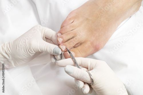 Female foot in the process of pedicure procedure in a beauty salon close-up.