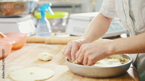 Cook is baking, forming and decorating meat pie in the bakery photo