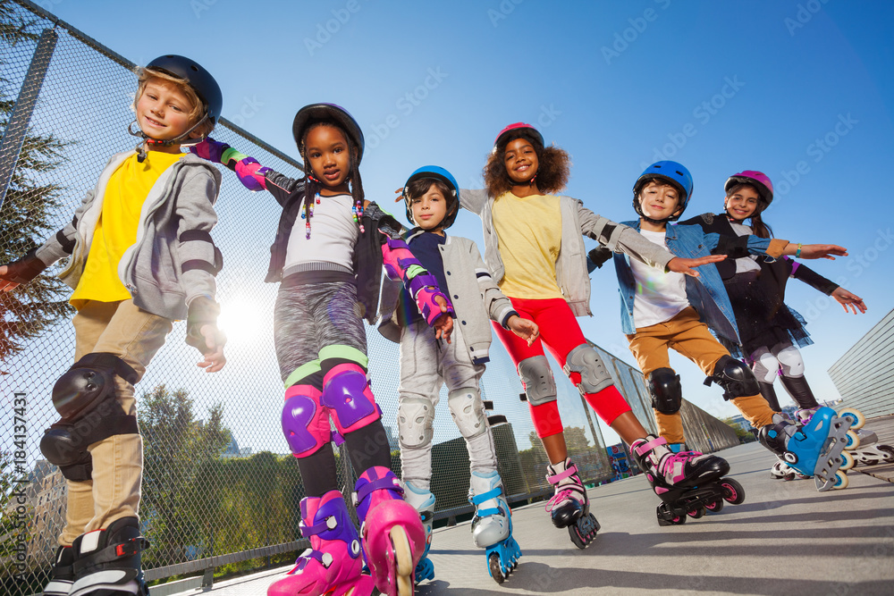 Happy kids rollerblading with hands like wings
