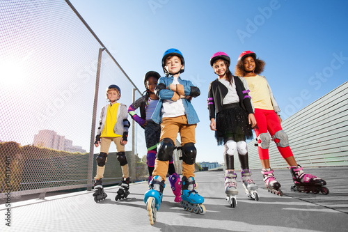 Foto Happy multiethnic kids in rollerblades  outdoors