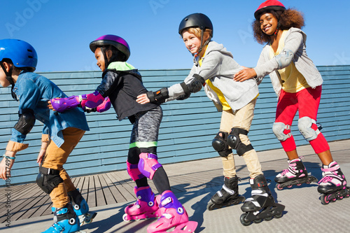 Happy friends having fun while rollerblading