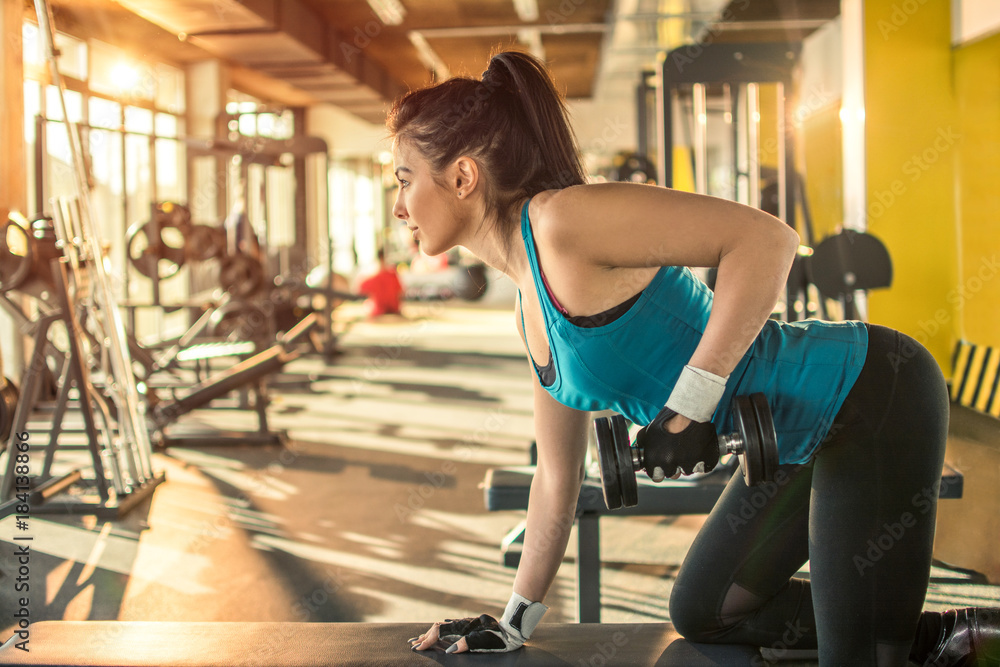 Sensual young woman with exercising with dumbbell in the gym. Sensual young woman with exercising with dumbbell in the gym.