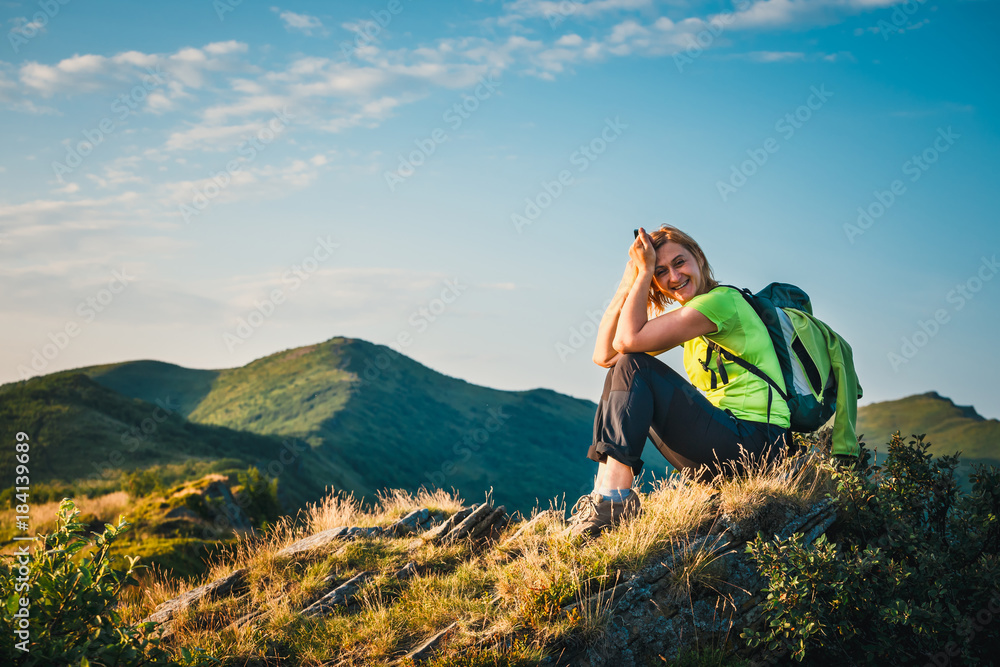 woman sits on the top and admires the beautiful sunrise