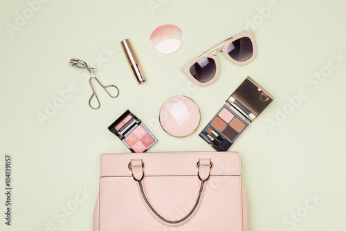 Makeup products with cosmetic bag on color background