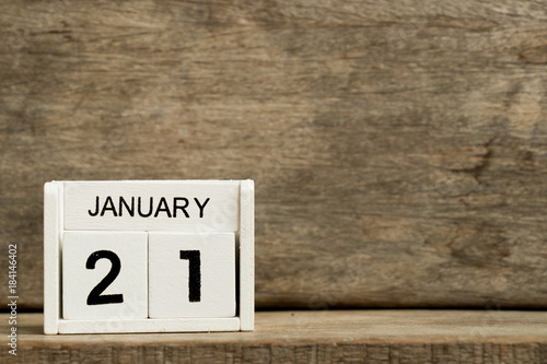 White block calendar present date 21 and month January on wood background