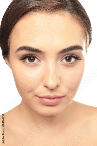 Portrait of beautiful young woman with eyelash extensions on white background