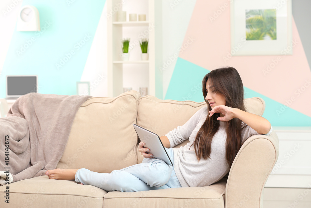 Young woman with tablet on sofa at home Young woman with tablet on sofa at home