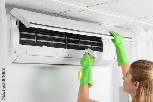 Young woman cleaning air co...