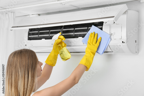 Young woman cleaning air co...