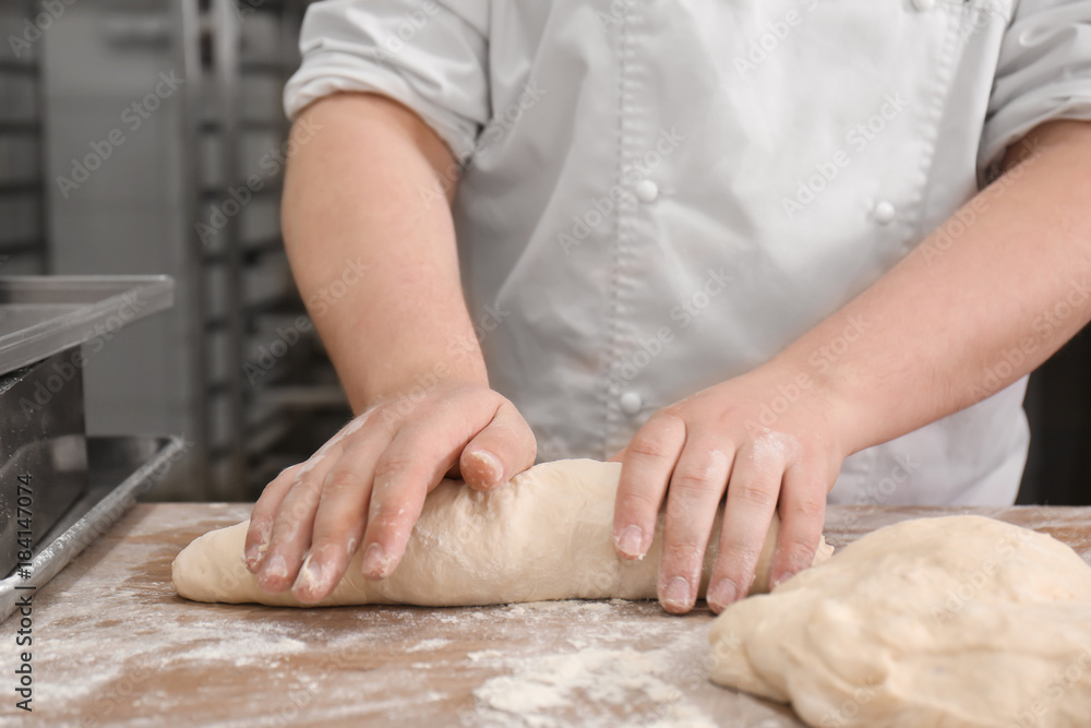 Man preparing bread on table in bakery Man preparing bread on table in bakery