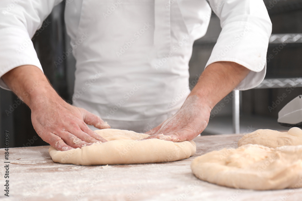 Man preparing bread on table in bakery