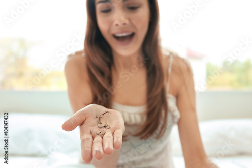 Emotional young woman holdi...