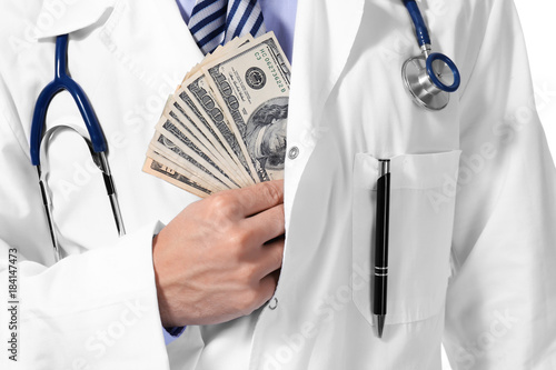 Doctor putting money in pocket on white background, closeup