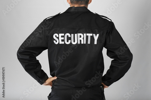 Male security guard on light background, closeup